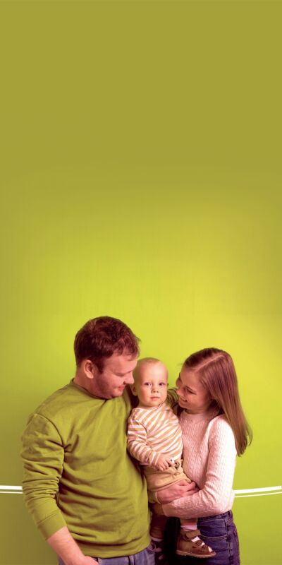 Une famille heureuse de trois personnes devant un fond vert